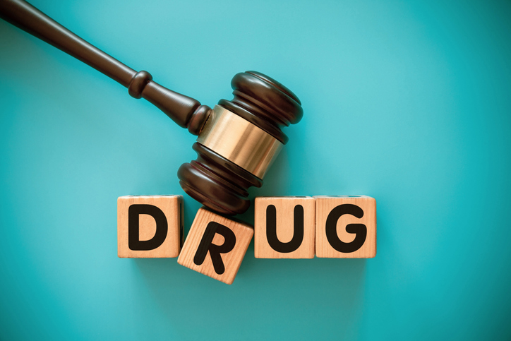 Gavel and toy block with DRUG
