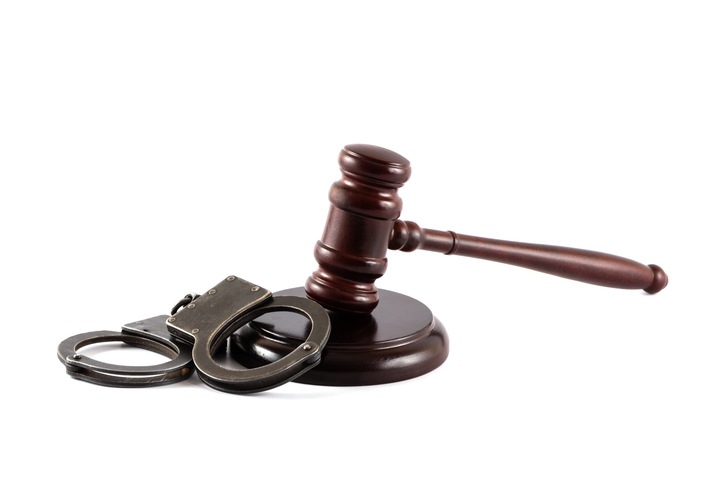 Handcuffs and judge's gavel on a white background