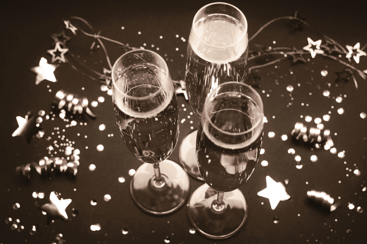 Celebratory champagne glasses among festive decorations in vintage sepia tone