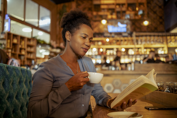 Escaping Into a Story: A Woman Deep in a Book at a Peaceful Coffee Shop