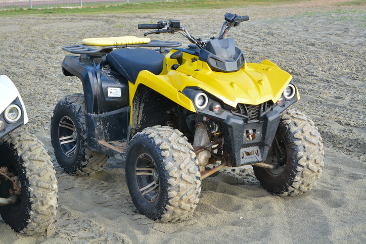 Kuantan, Malaysia: October 17th, 2024- The image shows a red and beige ATV parked in a sandy area.
