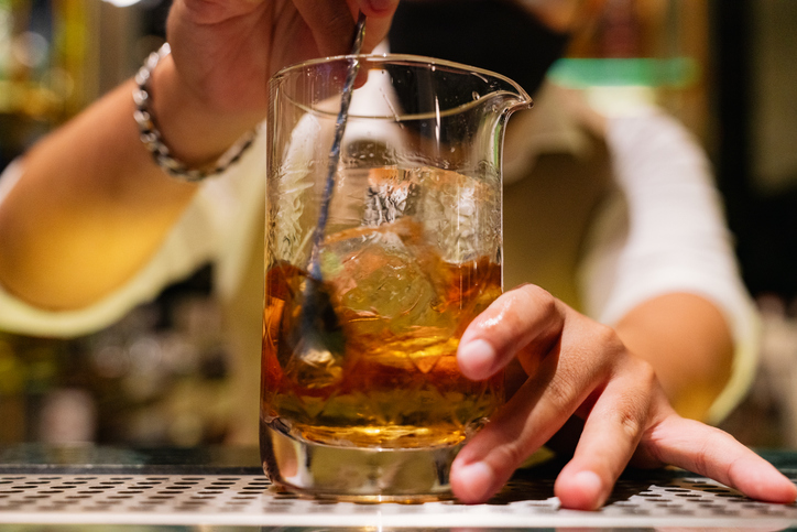Bartender Stirring a Cocktail with Precision in a Mixing Glass